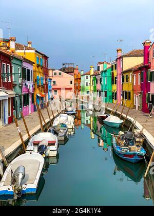 Boote anlegen und bunte Häuser in einer Grachtenstraße Häuser auf Burano Insel, Venedig, ein nicht erkennbarer Mensch auf dem Hintergrund. Stockfoto