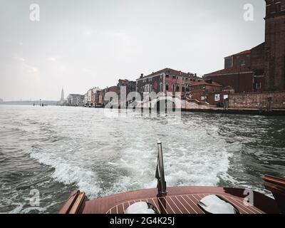 Blick auf die Lagune von einem Bootstaxi, das dahinter abfährt Venedig Stockfoto