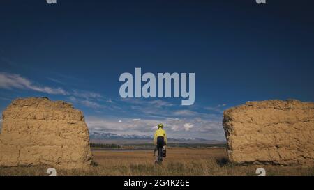 Die Frau reist auf gemischtem Terrain mit Bikepacking. Die Reise des Reisenden mit Fahrradtaschen. Sport Tourismus Bikepacking. Stockfoto
