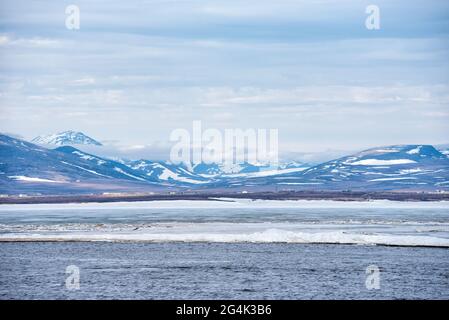 Landschaft mit Eisbruch in Tschukotka Meer gegen die verschneiten Hügel Stockfoto