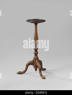 Gueridon in einer balusterförmigen Sorte. Gueridon aus Teak. Der mit Nieten und Grazien verzierte artikulierte Stamm ruht auf drei Düsenstellen, die an einem zylindrischen Teil des Stammes befestigt sind, einschließlich eines Schlussstücks. Die Beine zeigen Blattwerk auf den Schwellungen und enden in einem Ring mit Nieten und einer schlanken Tierklaue. Der Stamm ist weitgehend balusterförmig, vollständig mit stechenden Blättern bedeckt. Das runde Blatt geht diagonal zur Sorte und ist unten mit Grazien bedeckt. Stockfoto