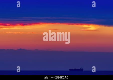 Goldgelb/orange Sonnenuntergang von Penmaenmawr, Clwyd Wales mit Blick über die Irische See in Richtung Puffin Island Stockfoto