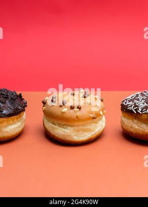 Köstliche glasierte Schokoladendonuts auf lebhaftem Hintergrund Stockfoto