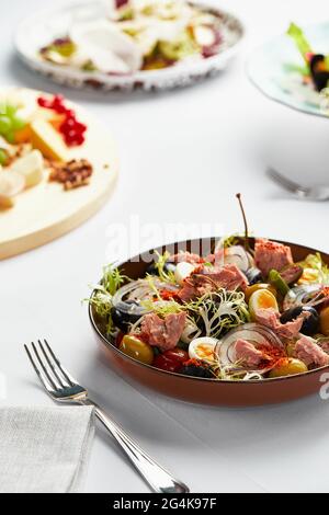 Klassischer Thunfisch-Nicoise-Salat mit Ei, Kartoffeln, s, Tomaten, Sardellen, Zwiebeln und Oliven, Vinaigrette-Sauce, Nicoise-Servieren des Autors Stockfoto