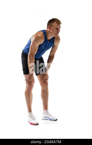 Kaukasischer Profisportler, Läufer, isoliert auf weißem Studiohintergrund stehend. Muskulöser, sportlicher Mann. Stockfoto