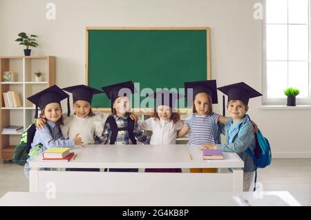 Porträt einer Gruppe von Absolventen des Kindergartens oder der Juniorklasse in Junggesellenhut oder Mortarboard. Stockfoto