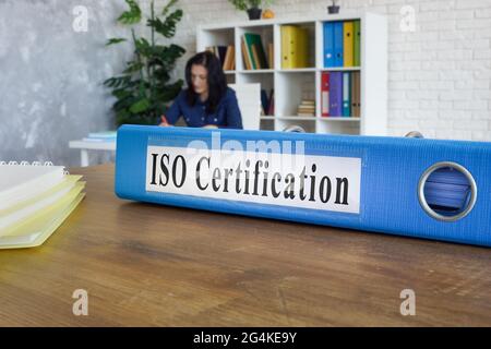 Ordner mit Leitfaden zur ISO-Zertifizierung auf dem Tisch. Stockfoto