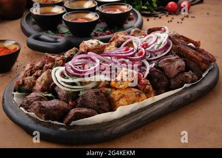 Gemischtes köstliches gegrilltes Fleisch mit Zwiebeln. BBQ-Sammlung in kaukasischen Restaurant. Stockfoto