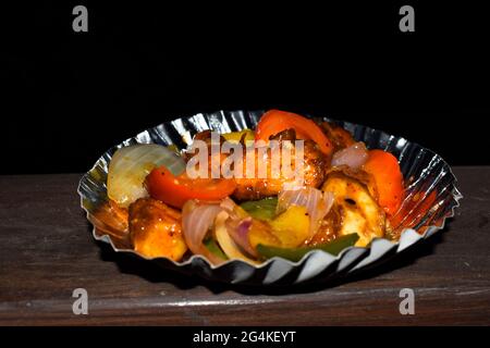 Paneer Chilly eine indische oder pakistanische Vorspeise, die aus Paneer oder Cottage-Käse und angebratener gelber, grüner, roter Paprika und Zwiebeln hergestellt wird. Seite vi Stockfoto