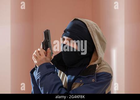 Unkenntlich männliche Person in der schwarzen Maske und Pistole, Outlaw und Verbrechen Konzept Stockfoto