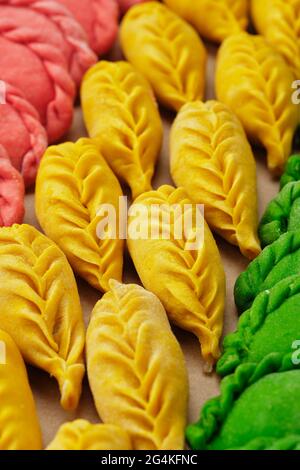 Klöße von Hand in verschiedenen grünen, gelben, roten Farben. Stockfoto