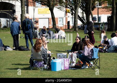 Sheffield UK: 17. April 2021: Gesellschaftlich distanziertes Geburtstagstreffen von Freunden im Freien, während die Parks nach der Pandemie-Sperre wieder geöffnet werden. Die neue normale ein Stockfoto