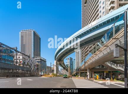 tokio, japan - 09 2021. april: Fußgängerüberfahrt auf der Shiodome Avenue, die von der automatisierten Fahrwegdurchfahrt der Tokyo New Transit Waterfront übersehen wird Stockfoto