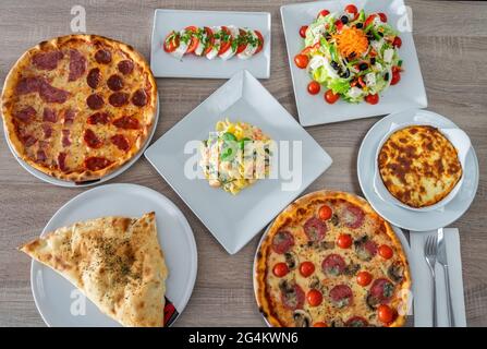 Vielfalt an Gerichten aus verschiedenen Kulturen, Pizzas, Salate, Pasta, Pfannkuchen Draufsicht. Nahaufnahme. Stockfoto