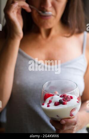 Attraktive Brünette im mittleren Alter spanische Frau posiert mit einem Glas Eis mit Früchten Stockfoto