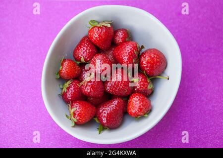 Draufsicht von frischen reifen Erdbeeren auf glitzerndem rosa Hintergrund Stockfoto
