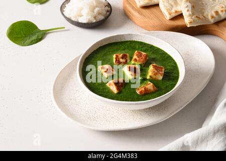 Palak Paneer mit Basmati-Reis auf weißem Hintergrund. Indische vegetarische Küche aus Spinat und Paneer-Käse. Nahaufnahme. Stockfoto