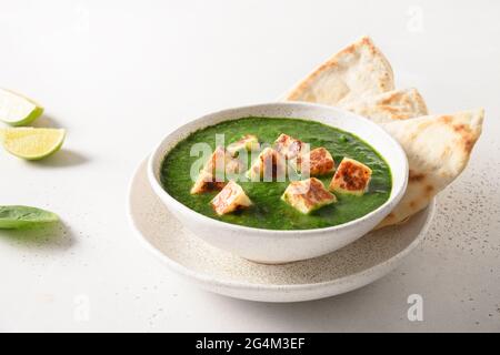 Palak Paneer mit Chapati auf weißem Hintergrund. Indische vegetarische Küche aus Spinat und Paneer-Käse. Nahaufnahme. Stockfoto