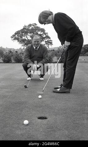 1970er Jahre, historisch, ein männlicher Golfer, der eine Putting-Lektion hat, England, Großbritannien. Putting ist ein wichtiger Teil des Golfspiels. Ein drei-Fuß-Put zählt als ein einziger Schlag, so viel wie ein dreihundert Yard Laufwerk und so sollten die meisten Amateur-Golfer auf die Verbesserung ihrer Putting konzentrieren, da Vertrauen in diesem Bereich des Spiels ist ein großer Vorteil für niedrigere Golf-Scores. Stockfoto