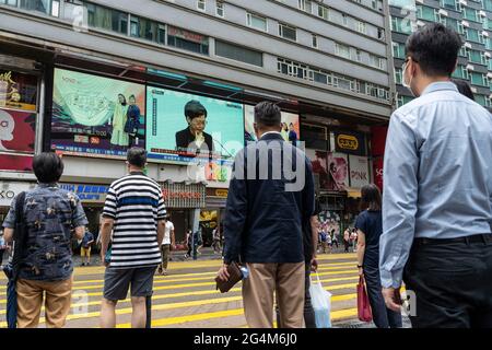 Hongkong, China. Juni 2021. Fußgänger werden vor einem Bildschirm gesehen, der die Pressekonferenz von Carrie Lam, Hongkongs Chief Executive, im Tsim Sha Tsui Bezirk berichtet. (Foto von Chan Long Hei/SOPA Images/Sipa USA) Quelle: SIPA USA/Alamy Live News Stockfoto