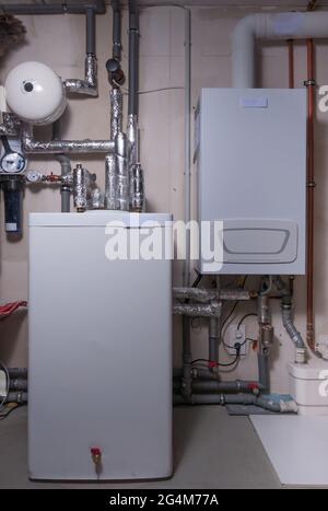 Neu erbautes Heizsystem mit thermischem Speicher und Expansionstank. Installiert im Keller eines Familienhauses Stockfoto