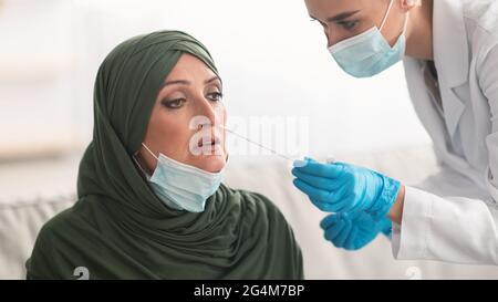 Krankenschwester, die muslimischen Patienten auf Coronavirus testet und PCR-Test in Innenräumen macht Stockfoto