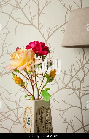 Foto einer roten Rose und einer gelben Rose in einer braunen Vase.Es ist ein Foto, das darauf abzielt, die Natürlichkeit eines Blumenstraußes in einem Haus zu zeigen.das Foto Stockfoto