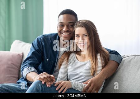 Porträt Eines Lächelnden Jungen Multikulturellen Paares, Das In Der Inneneinrichtung Posiert Stockfoto