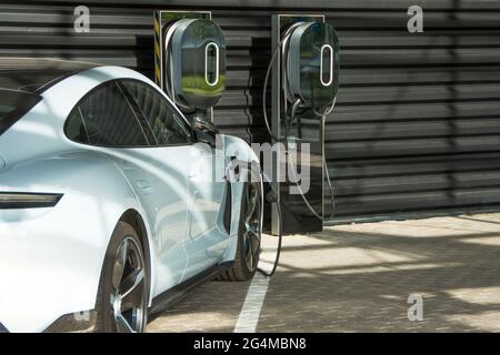 PKW in der Nähe der Garage neben den Batterieladestationen Stockfoto