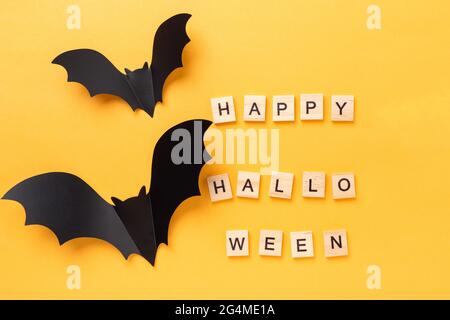 Halloween flach lag mit Text Happy Halloween und zwei fliegende Fledermaus auf gelbem Hintergrund - Bild Stockfoto