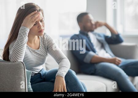 Verärgert Junge Interracial Ehegatten Sitzen Auf Der Couch, Ignorieren Einander Nach Streit Stockfoto