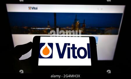 Person, die Mobiltelefon mit dem Logo der niederländischen Handelsgesellschaft Vitol Holding B.V. auf dem Bildschirm vor der Geschäftswebseite hält. Konzentrieren Sie sich auf die Telefonanzeige. Stockfoto