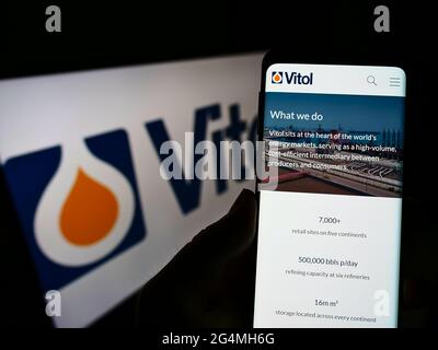 Person, die Mobiltelefon mit der Webseite der niederländischen Handelsgesellschaft Vitol Holding B.V. auf dem Bildschirm vor dem Logo hält. Konzentrieren Sie sich auf die Mitte des Telefondisplays. Stockfoto