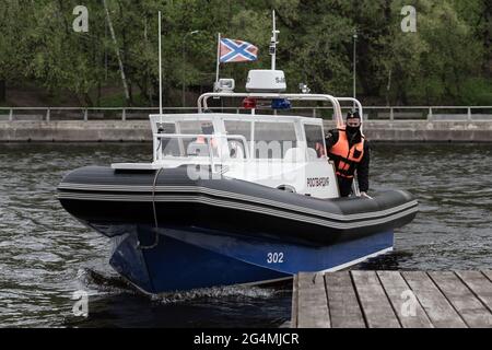 Das Rosgvardia-Boot nähert sich dem Pier.im Frühjahr 2020 wurden aufgrund des Ausbruchs einer neuen Coronavirus-Infektion in Moskau anti-epidemiologische Maßnahmen eingeführt. Ohne unnötige Notwendigkeit wurde den Bürgern geraten, nicht an öffentliche Orte zu gehen, und alle Bewegungen in der Stadt mussten mit medizinischer Schutzausrüstung und mit einem elektronischen Pass durchgeführt werden. Die Durchsetzung restriktiver Maßnahmen auf den Straßen der Stadt wurde von der Polizei und der Nationalgarde überwacht. Flußboote, Drohnen und Ka-226-Hubschrauber wurden eingesetzt, um Übertreter der Beschränkungen zu kontrollieren. (Foto von Mihail Stockfoto