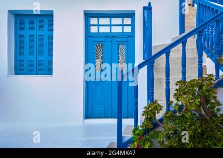 Traditionelle griechische Veranda, weiß getünchte Wände, blaue Fensterläden, Tür und Türen, Treppengeländer. Einzigartiges Design der mediterranen Insel. Stockfoto