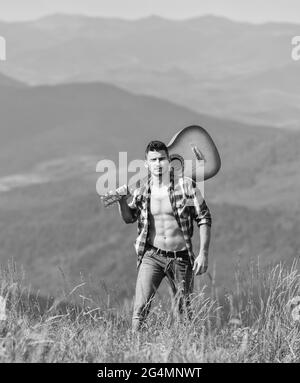 Urlaubsziele. Allein zu Fuß. Mann mit Gitarre, der auf dem Berg läuft. Die beste Art, aus der Stadt zu entkommen. Guy Wanderer genießen Natur pur. Erkunden Stockfoto