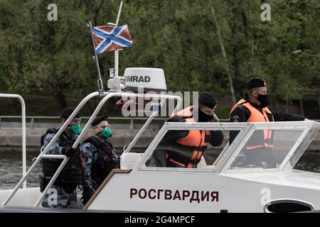 Rosgvardia Patrouillenboot mit einer Gruppe von Bereitschaftspolizisten.im Frühjahr 2020 wurden aufgrund des Ausbruchs einer neuen Coronavirus-Infektion in Moskau anti-epidemiologische Maßnahmen eingeführt. Ohne unnötige Notwendigkeit wurde den Bürgern geraten, nicht an öffentliche Orte zu gehen, und alle Bewegungen in der Stadt mussten mit medizinischer Schutzausrüstung und mit einem elektronischen Pass durchgeführt werden. Die Durchsetzung restriktiver Maßnahmen auf den Straßen der Stadt wurde von der Polizei und der Nationalgarde überwacht. Flußboote, Drohnen und Ka-226-Hubschrauber wurden eingesetzt, um Übertreter der Beschränkungen zu kontrollieren. Stockfoto