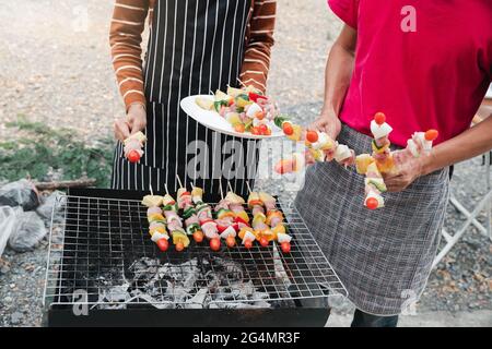Ein Paar gegrillt Schweinefleisch und Grill in Dinner-Party. Essen, Menschen und Familienzeitkonzept. Stockfoto
