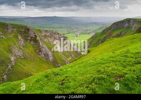 Blick nach Osten in Richtung Hope Valley durch hohe Riffkalkplatten am Winnats Pass, einer tiefen Einschnittschlucht in Castleton, Hope Valley. Stockfoto