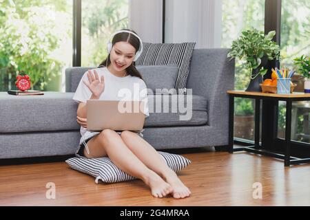 Geschäftsfrau winkt mit den Händen, um das Geschäftsteam bei einer Videokonferenz zu Hause zu begrüßen. Webinar, Social Distancing, E-Learning und Seminar online concep Stockfoto