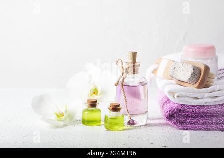 Parfümflasche, Öl und Orchideenblüten. Aromatisches kosmetisches Produkt, Spa-Behandlungen. Stockfoto