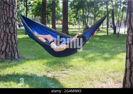 Junger Mann hat eine Pause im Sommer in einer Hängematte Stockfoto