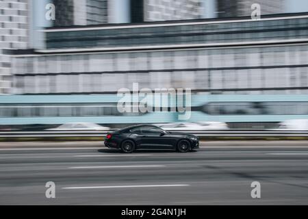 Ukraine, Kiew - 29. April 2021: Schwarzer Ford Mustang Auto bewegt sich auf der Straße. Redaktionell Stockfoto