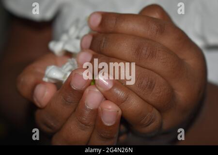 Colombo, Sri Lanka. Juni 2021. Ein drei Jahre altes Kind trägt weiße Blumen in Vorbereitung auf eine Kindertagesveranstaltung zum Gedenken an den Poya-Vollmond-Tag von Poon, der am Donnerstag, dem 24. Juni, fällt. Poson Poya ist nach Vesak an zweiter Stelle und erinnert an die Einführung des Buddhismus in Sri Lanka durch den buddhistischen Missionsmönch Mahinda im 3. Jahrhundert v. Chr. Quelle: Majority World CIC/Alamy Live News Stockfoto