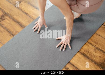 Verkürzte Ansicht einer reifen Frau, die Yoga oder Pilates auf einer Matte macht Stockfoto