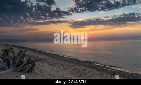 Der Sonnenuntergang geht über einem einsamen Lake Superior Strand im Muskallonge Lake State Park, Michigan, hinab Stockfoto