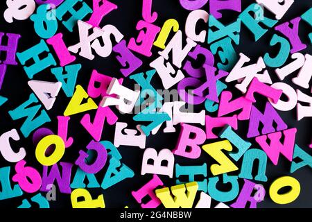 Bunte hölzerne englische Alphabet Buchstaben Draufsicht auf schwarzem Hintergrund Stockfoto