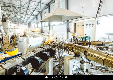 Werkstatt mit Extrudern zur Herstellung von Kunststoffrohren. High-Speed-Extrusionslinie von Wasser supply und Gasleitung. Fertigungsstätte. Stockfoto