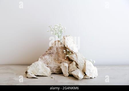 Leere graue Steine Turm Podium. Stones Podest Display auf beigefarbenem Beton Hintergrund aus Steinen Blumen Modell für Produktpräsentation. Stockfoto