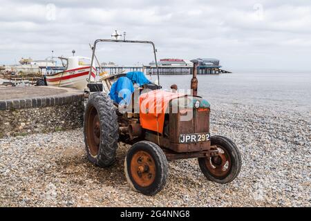 Alter Traktor am Strand von Cromer bereit, Fischerboote von der Nord-Norfolk-Küste zu erholen, gesehen im Juni 2021. Stockfoto